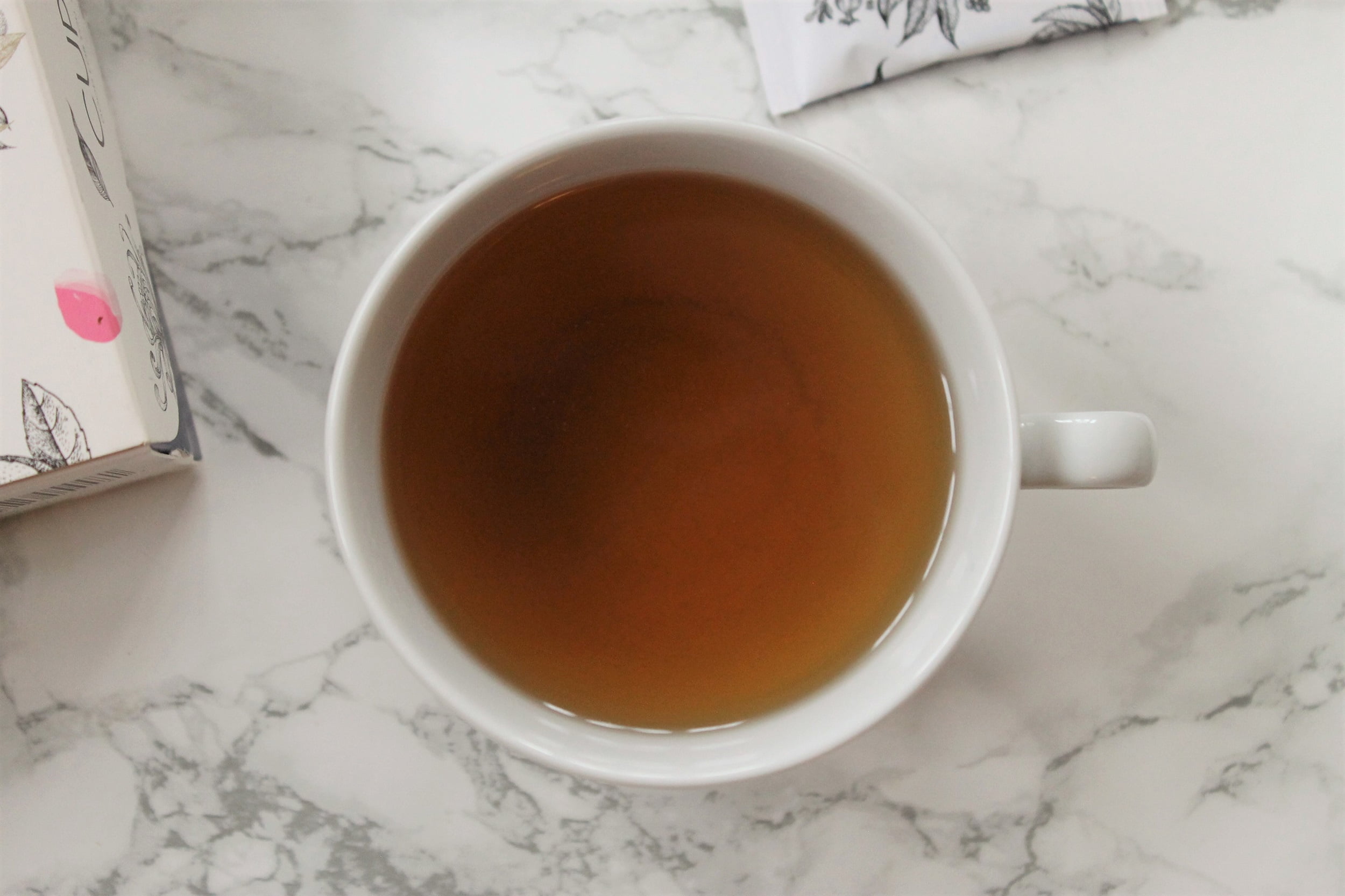 orange brown tea in white teacup