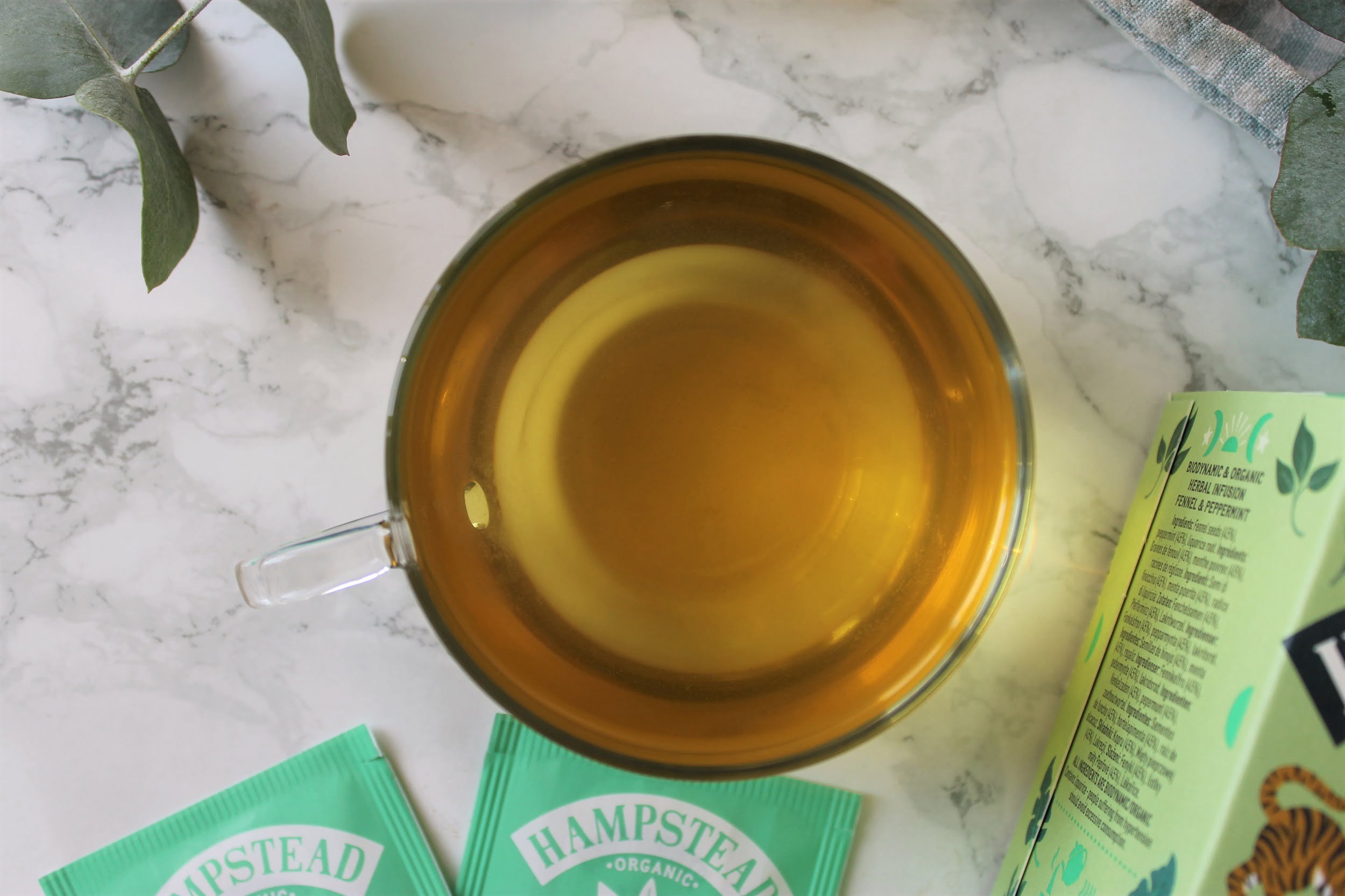 golden herbal tea in a glass teacup