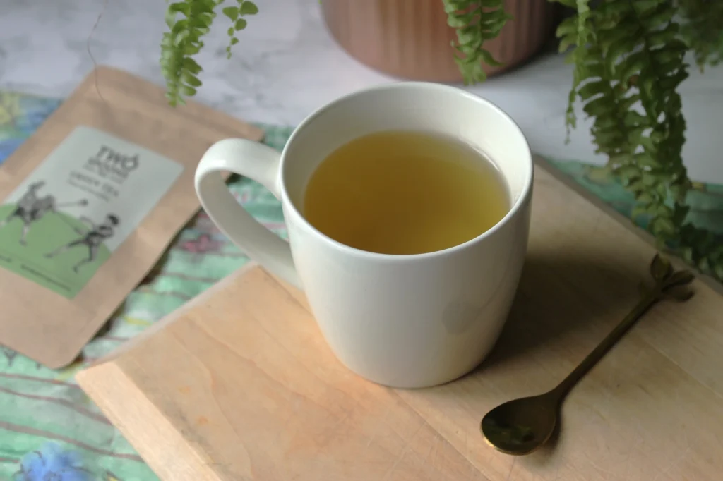 two spoons tea green tea in white teacup
