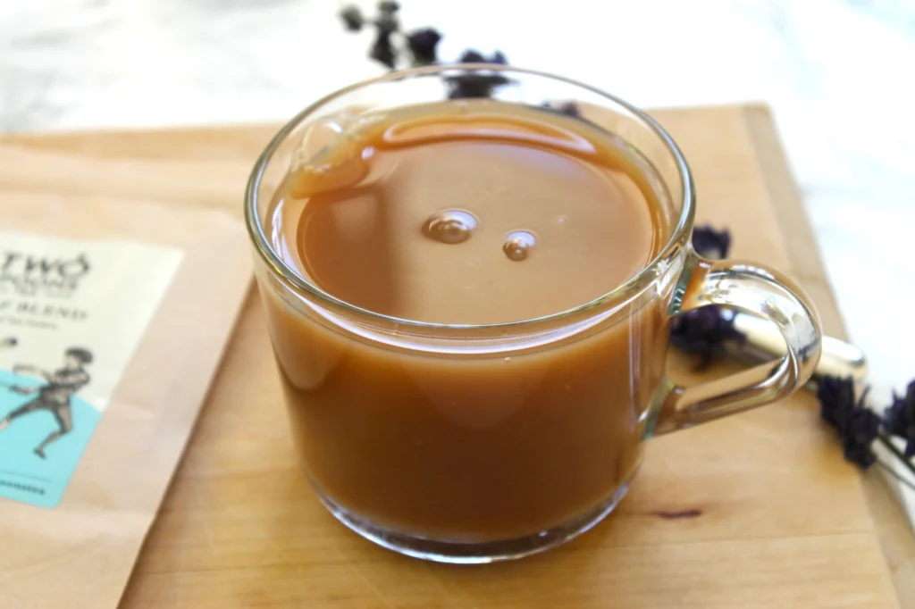 decaf black tea with milk in a glass teacup